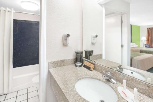 a bathroom with a sink and a large mirror at Super 8 by Wyndham Mobile in Mobile