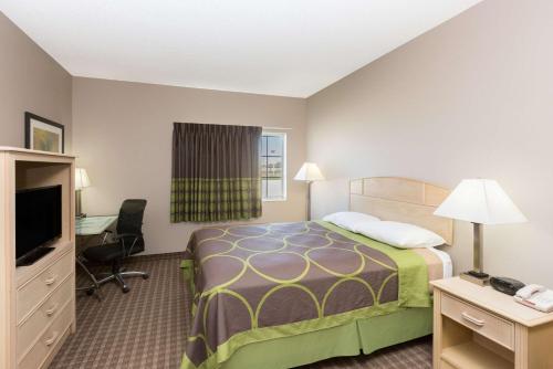a hotel room with a bed and a desk at Super 8 by Wyndham Carroll/East in Carroll
