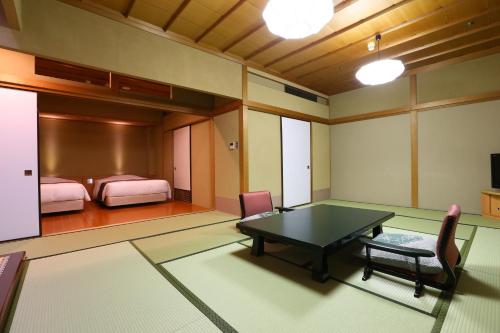 um quarto com uma mesa e cadeiras e um quarto em Tsubaki em Yugawara