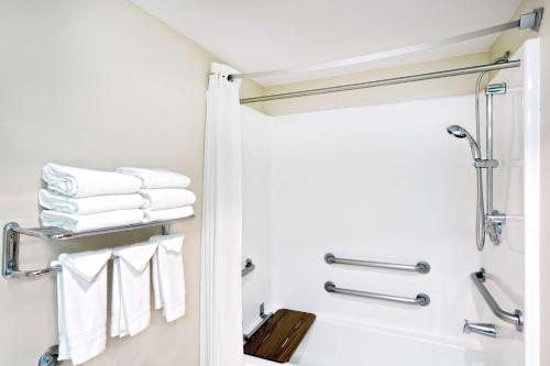 a bathroom with a shower and white towels at Super 8 by Wyndham Heyburn in Burley