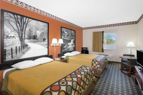 a hotel room with two beds and a flat screen tv at Super 8 by Wyndham Athens in Athens