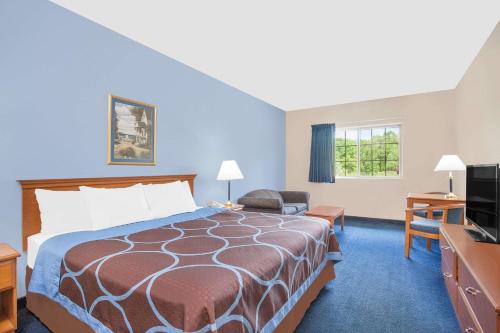 ein Hotelzimmer mit einem Bett und einem TV in der Unterkunft Super 8 by Wyndham Cobleskill NY in Cobleskill
