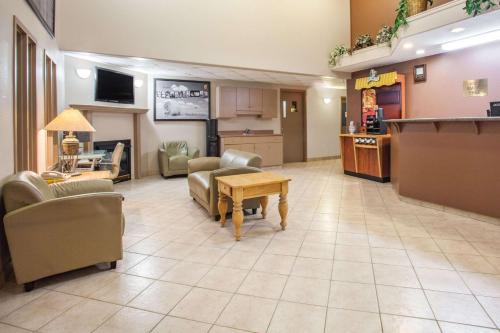 a living room filled with furniture and a tv at Super 8 by Wyndham Meadow Lake in Meadow Lake