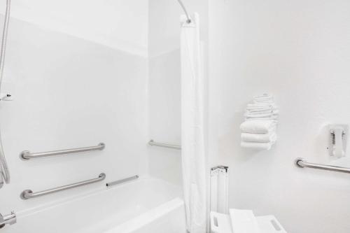 ein weißes Bad mit einer Dusche und einer Badewanne in der Unterkunft Super 8 by Wyndham Cobleskill NY in Cobleskill