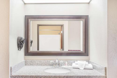 a bathroom with a sink and a mirror at Super 8 by Wyndham Central City in Central City