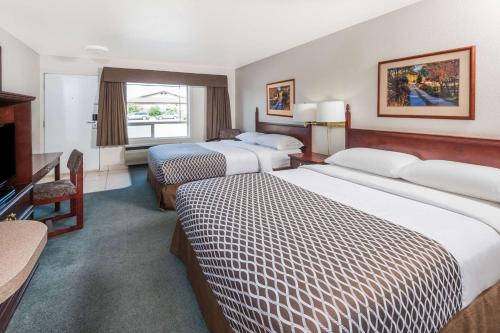 Habitación de hotel con 2 camas y TV en Super 8 by Wyndham High River AB en High River