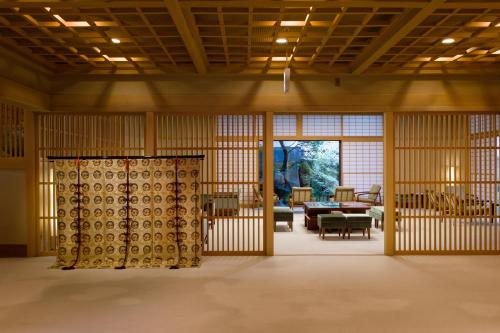 a room with bamboo walls and a table and chairs at Oku Yugawara Tsubaki in Yugawara