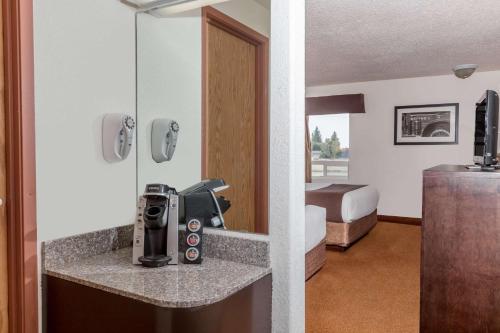 a hotel room with a sink and a bed at Super 8 by Wyndham Vermilion AB in Vermilion