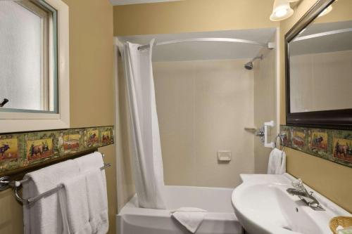 a bathroom with a shower and a sink and a toilet at Super 8 by Wyndham Lake George/Downtown in Lake George