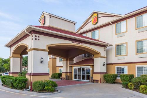 a hotel with a sign on the front of a building at Super 8 by Wyndham Hillsboro TX in Hillsboro