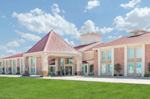 a large building with a green lawn in front of it at Super 8 by Wyndham Oklahoma City in Oklahoma City