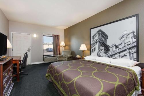 a hotel room with a bed and a large painting on the wall at Super 8 by Wyndham Petersburg in Petersburg