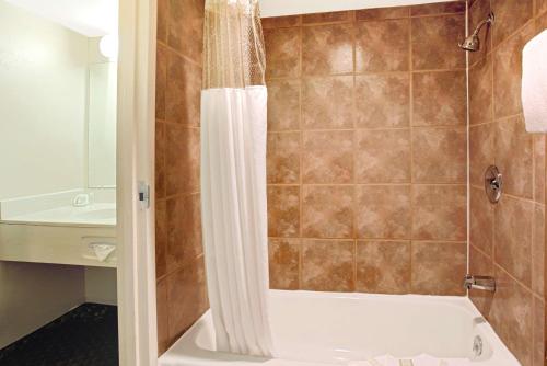 麥嶺的住宿－速8丹佛西酒店，带浴缸和盥洗盆的淋浴浴室
