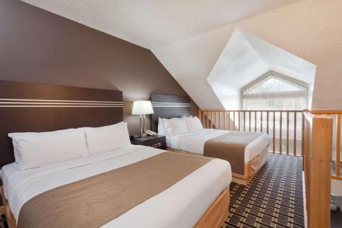 a hotel room with two beds and a window at Super 8 by Wyndham Valemount in Valemount