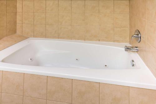 a large white bath tub in a bathroom at Global Inn in Coos Bay