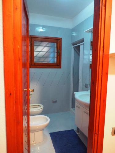 a bathroom with a toilet and a sink and a window at Villa Rux in Santa Luria