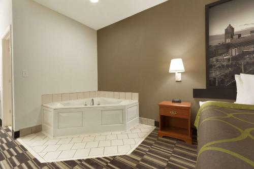 a hotel room with a tub and a bed at Super 8 by Wyndham Chatsworth/Dalton in Chatsworth