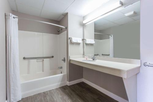 ein Badezimmer mit einem Waschbecken, einer Badewanne und einer Dusche in der Unterkunft Super 8 by Wyndham Petersburg in Petersburg