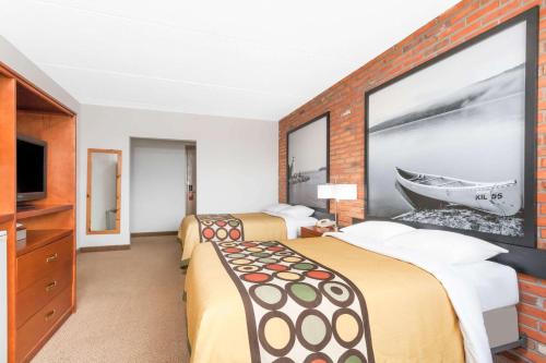 a hotel room with two beds and a tv at Super 8 by Wyndham Sudbury ON in Sudbury