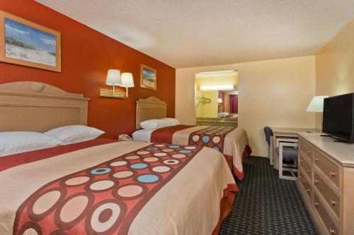 a hotel room with two beds and a television at Super 8 by Wyndham Chipley in Chipley