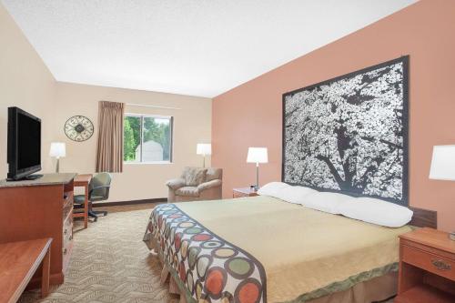 a hotel room with a bed and a television at Super 8 by Wyndham Central City in Central City