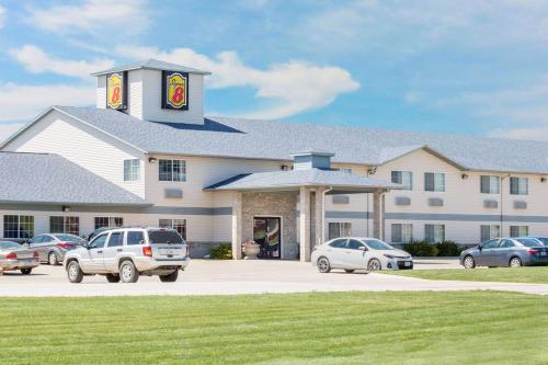 a large building with cars parked in a parking lot at Super 8 by Wyndham Carroll/East in Carroll