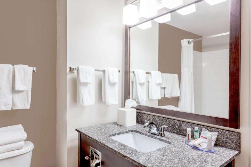 Super 8 by Wyndham Prince Albert في برينس ألبرت: حمام مع حوض ومرآة