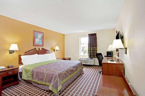 a hotel room with a bed and a window at Super 8 by Wyndham Forrest City AR in Forrest City