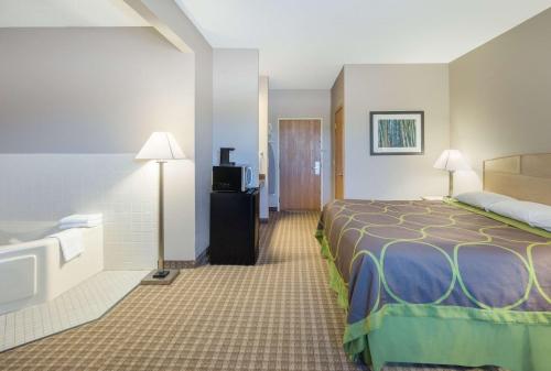 A bed or beds in a room at Super 8 by Wyndham Carroll/East