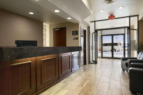 an office lobby with a reception counter and a couch at Super 8 by Wyndham Fox Creek in Fox Creek