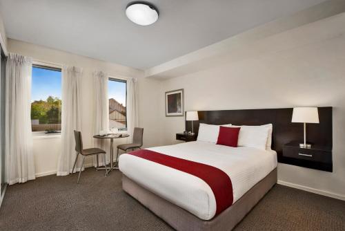 um quarto de hotel com uma cama grande e uma secretária em Quest Moonee Valley em Melbourne