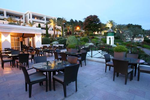 een restaurant met tafels en stoelen op een patio bij Royal Mougins Golf, Hotel & Spa de Luxe in Mougins
