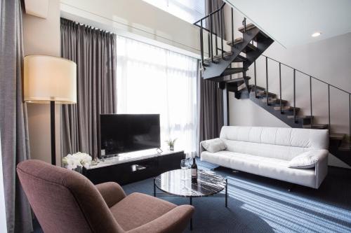 a living room with a couch and a tv at Centum Primus Hotel in Busan