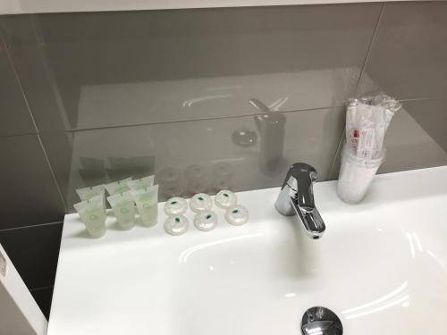 a bathroom sink with a faucet and a counter top at Hotel Restaurante Santa Cruz in Santa Cruz de Mudela