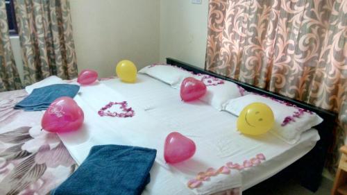 a bed with some heart balloons on top of it at Skylarc Inn in Ooty