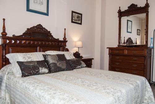 a bedroom with a bed and a dresser and a mirror at El Palacete in Setenil