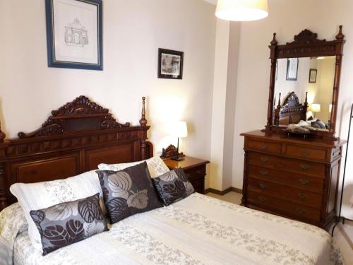 a bedroom with a bed and a dresser and a mirror at El Palacete in Setenil
