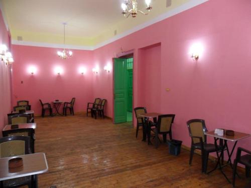 a room with pink walls and tables and green door at Berlin Hotel in Cairo