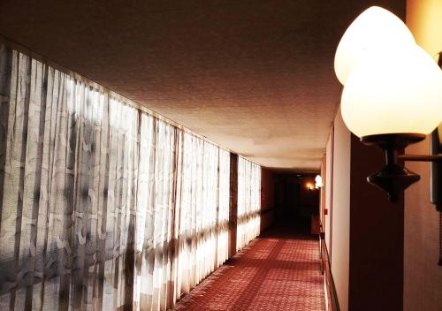 a hallway of a building with a light on the wall at Oriental Palace Hotel in Manama