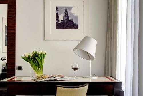 a desk with a lamp and a glass of wine at Milano Castello Luxury Apartment in Milan