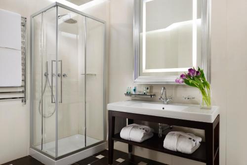a bathroom with a sink and a glass shower at Milano Castello Luxury Apartment in Milan