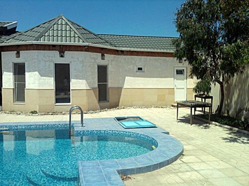 a swimming pool in front of a building at Shuvelan Cottage House in Şüvǝlǝn