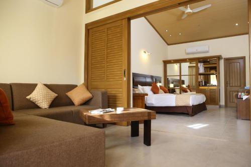 a living room with a couch and a bed at Dreamworld Resort, Hotel & Golf Course in Karachi