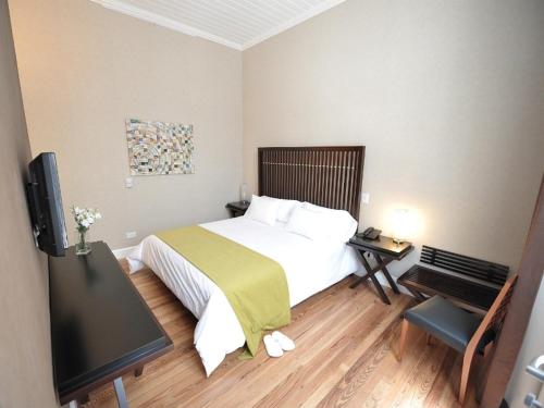 a bedroom with a bed and a flat screen tv at Patios de San Telmo in Buenos Aires