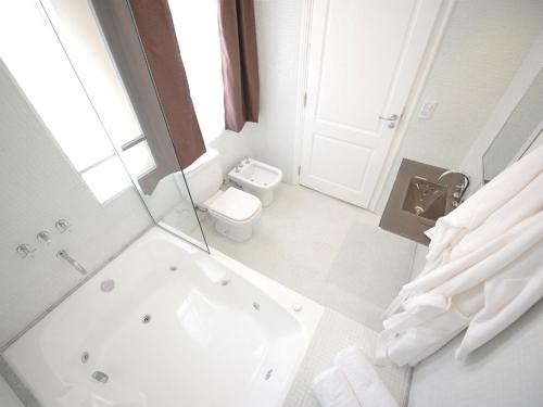 a white bathroom with a tub and a toilet at Patios de San Telmo in Buenos Aires