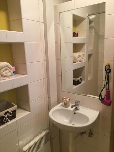 a white bathroom with a sink and a mirror at Sausage dog's apartments in Olomouc