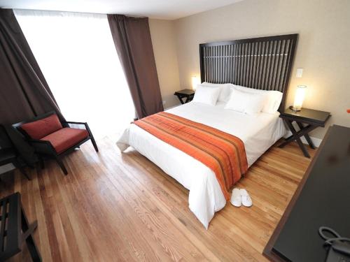 a bedroom with a large bed and a red chair at Patios de San Telmo in Buenos Aires
