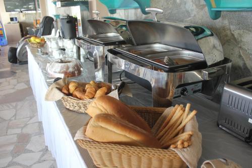 a buffet line with baskets of bread and pastries at Santa Rosa Hotel & Beach in Alexandroupoli