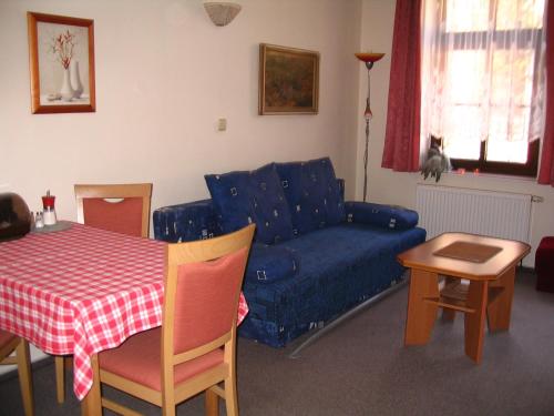 a living room with a blue couch and a table at Apartmany Ingeborg in Jáchymov