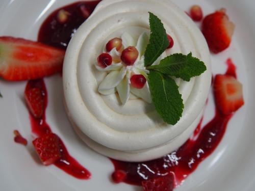 a dessert on a white plate with fruit and sauce at Hotel Spichlerz Lubawa in Lubawa